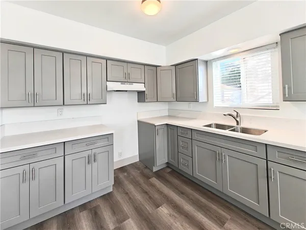 a kitchen with white cabinets white appliances and sink
