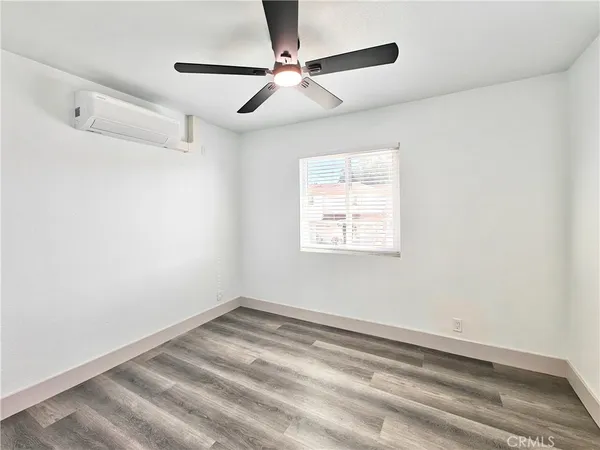 an empty room with a window and a fan