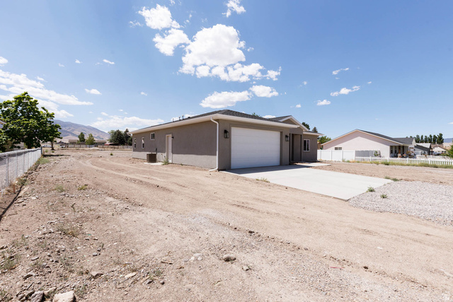 51 West 500 South Monroe, UT 84754 - Photo 24 of 41 Contemporary ranch-style residence featuring a two-car garage, stucco exterior, and concrete driveway