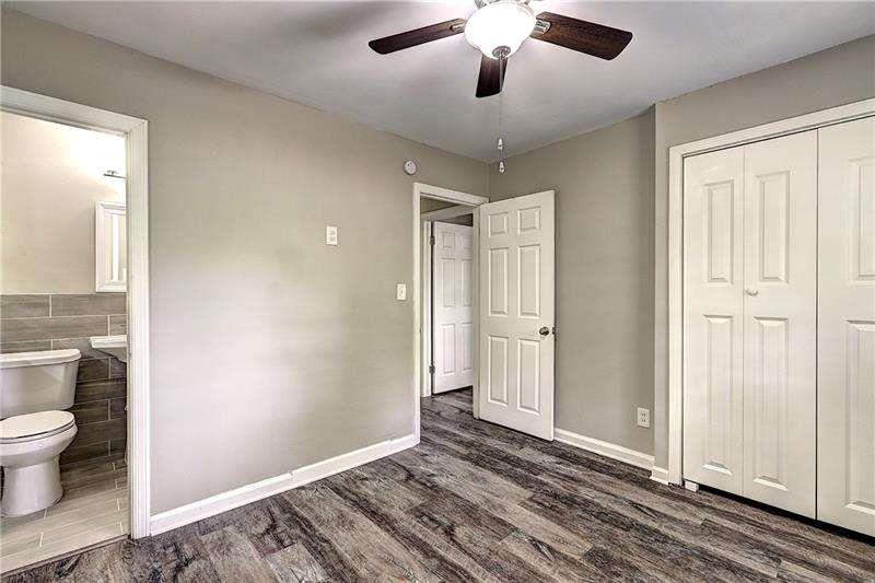 4973 White Boulevard Southwest Mableton, GA 30126 - Photo 12 of 22 an empty room with wooden floor fan and windows