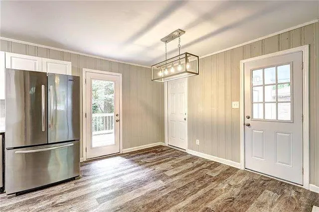 a view of a kitchen with wooden floor and a refrigerator