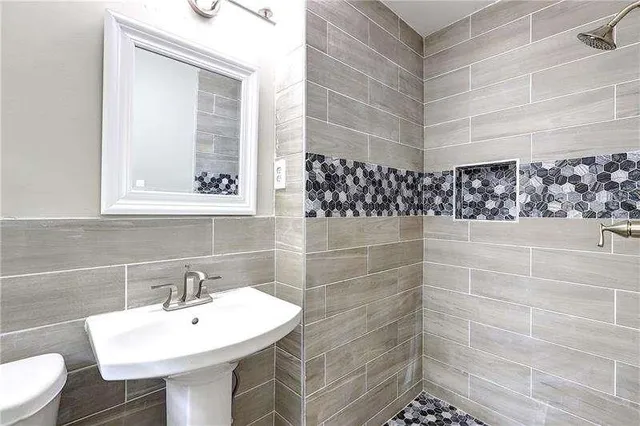 a bathroom with a sink a toilet and mirror