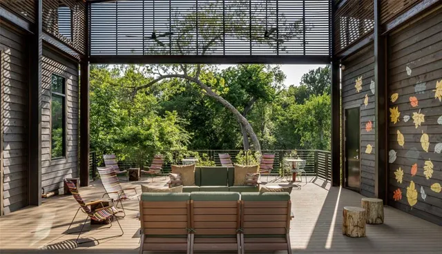 a living room with furniture large windows and wooden floor