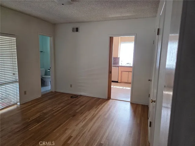 a view of a room with wooden floor and a window
