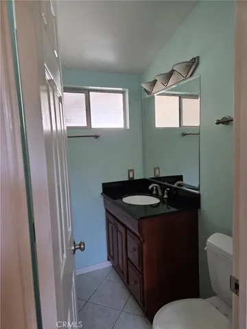 a bathroom with a granite countertop sink a toilet and a mirror