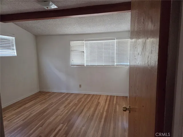 a view of a room with wooden floor and windows