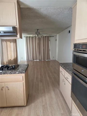 a kitchen with granite countertop a sink stove and cabinets