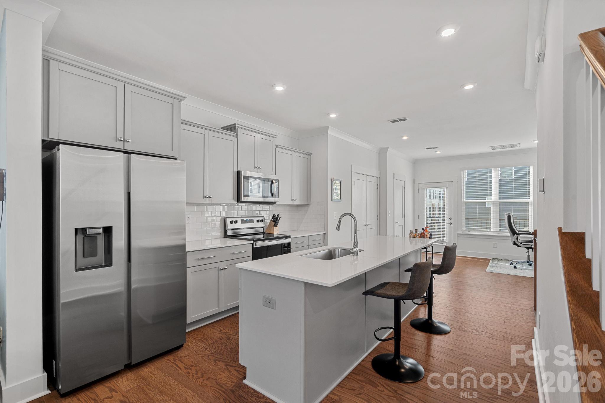 4012 Capital Ridge Charlotte, NC 28205 - Photo 8 of 28 a kitchen with stainless steel appliances a refrigerator a stove a sink a dining table and chairs