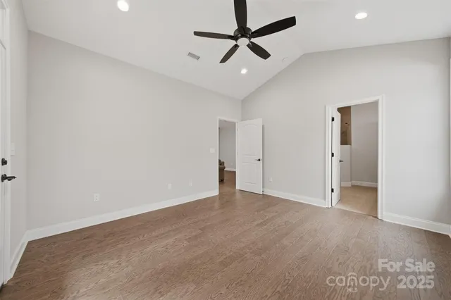 an empty room with closet and a ceiling fan
