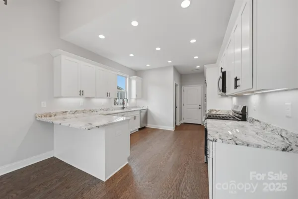 a kitchen with stainless steel appliances granite countertop a sink stove and refrigerator