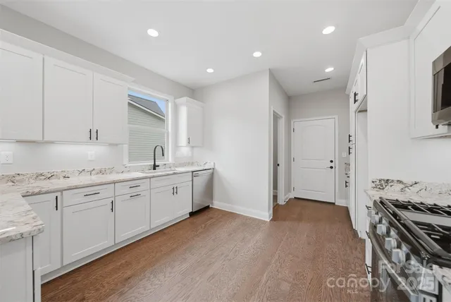 a spacious bathroom with a granite countertop sink and a mirror