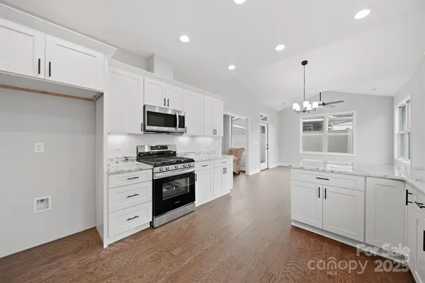 a large kitchen with stainless steel appliances granite countertop a stove and a sink