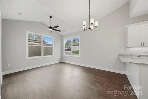 a view of a livingroom with a ceiling fan window and a kitchen view