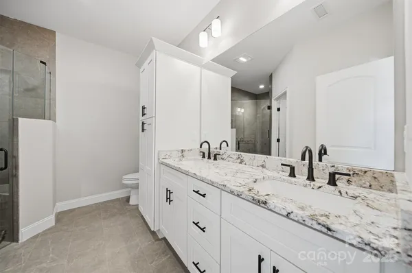 a bathroom with a granite countertop sink mirror and toilet
