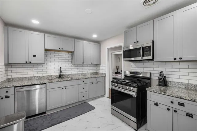 a kitchen with stainless steel appliances granite countertop a stove sink microwave and cabinets