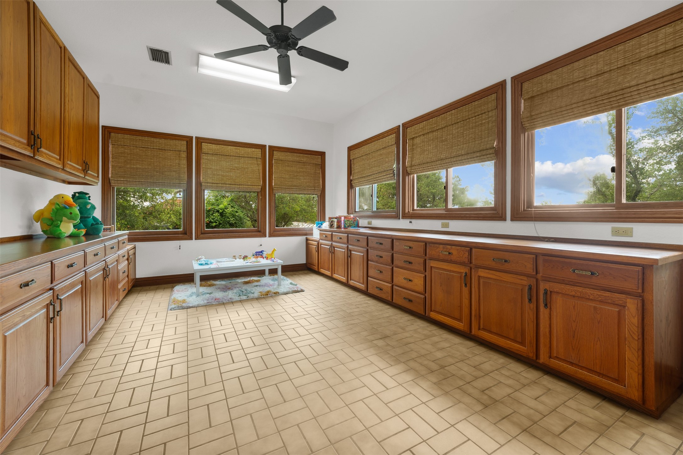 34000 Smithson Valley Road Bulverde, TX 78163 - Photo 27 of 50 A dedicated craft and hobby room offers extensive built-in cabinetry, generous counter space, and abundant natural light. Perfect for creative projects, homeschooling, or additional storage needs. This room is off the garage.