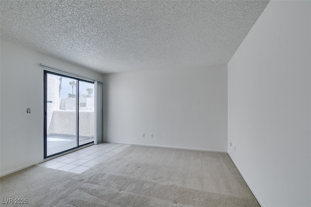 2681 Ruthe Duarte Avenue Las Vegas, NV 89121 - Photo 34 of 43 Empty room with baseboards, a textured ceiling, and light colored carpet