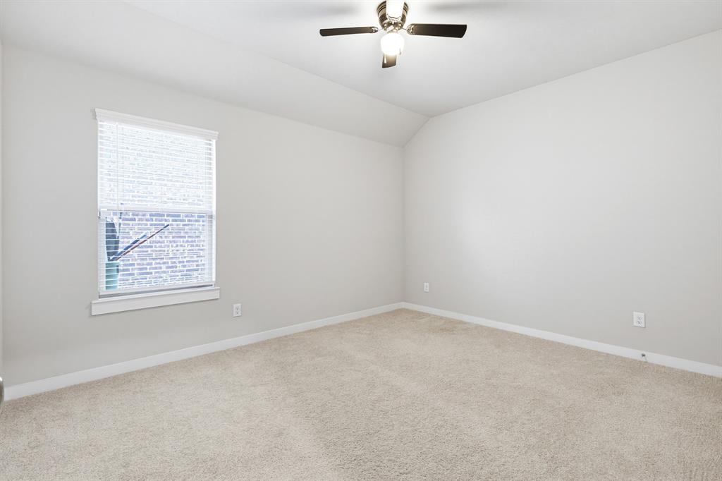 2108 Mossfield Lane Forney, TX 75126 - Photo 27 of 28 Neutral tone wall paint, vaulted ceiling, and flush-mount ceiling fan with light fixture