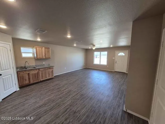 a view of a kitchen with wooden floor and a sink