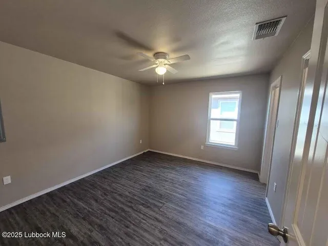 an empty room with wooden floor and window