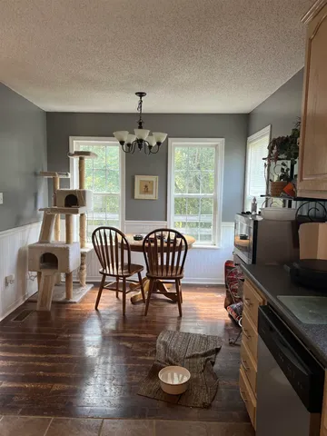 a dining room with furniture a chandelier and wooden floor