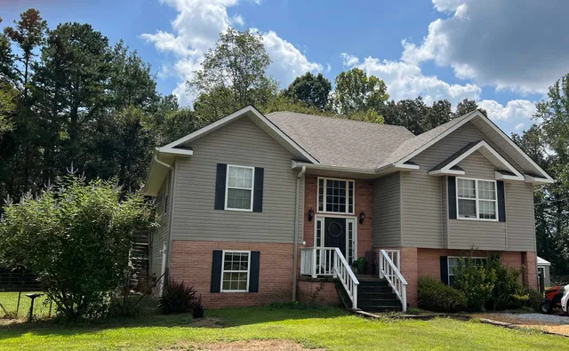 a front view of a house with a yard garage and outdoor seating