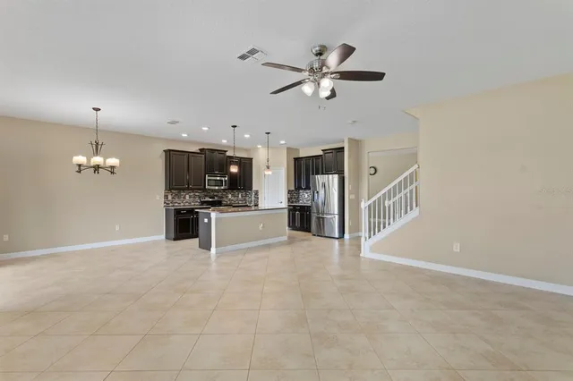 a kitchen with stainless steel appliances kitchen island granite countertop a refrigerator and a stove top oven
