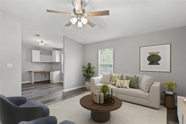 a view of an empty room with wooden floor fireplace and a window