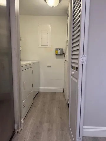 a view of an empty room with window and chandelier fan