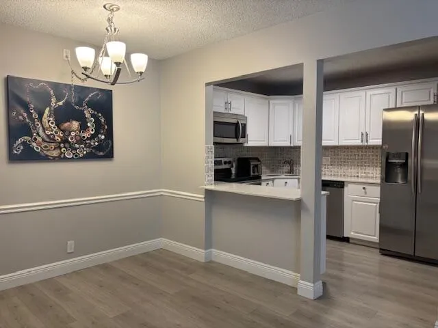 a kitchen with stainless steel appliances granite countertop a refrigerator and a stove top oven