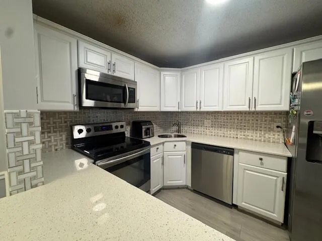 a kitchen with stainless steel appliances a stove microwave and sink