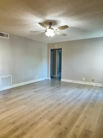 a view of an empty room with wooden floor