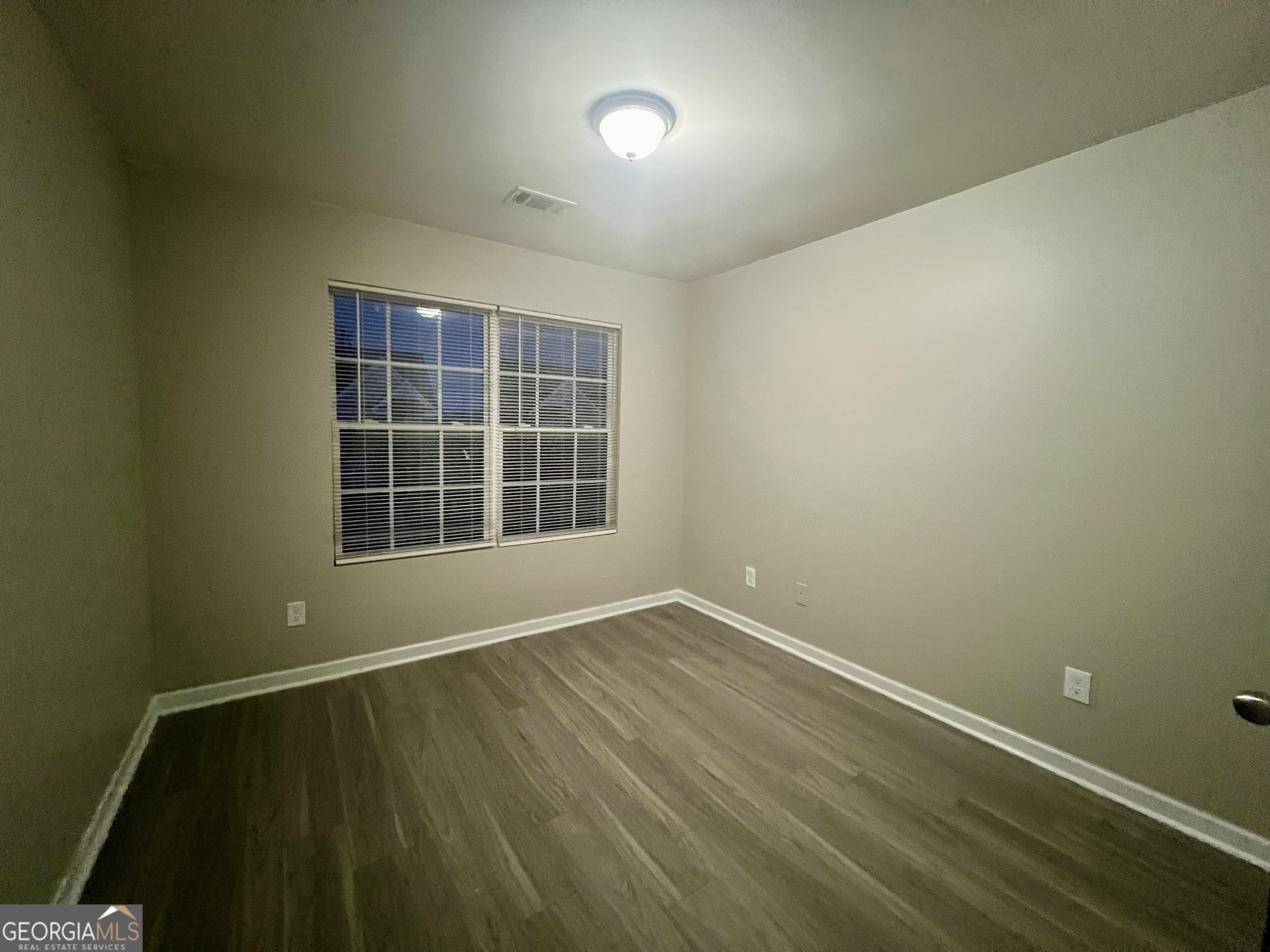 1005 Mill Creek Way, Unit B Monroe, GA 30655 - Photo 7 of 11 a view of an empty room with wooden floor and a window