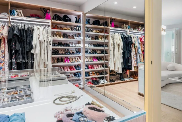 a view of walk in closet with clothes and shoes