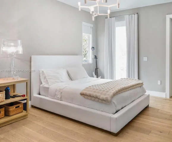 a spacious bedroom with a bed and a chandelier