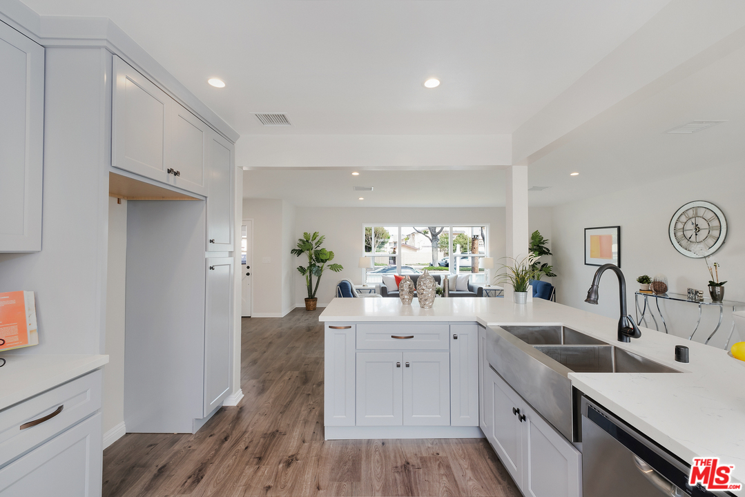 13927 Studebaker Road Norwalk, CA 90650 - Photo 11 of 27 a large white kitchen with a sink a window and stainless steel appliances