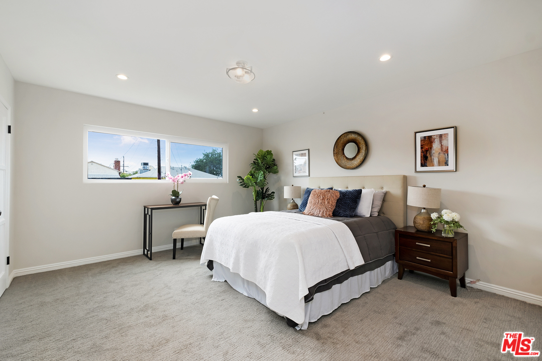 13927 Studebaker Road Norwalk, CA 90650 - Photo 12 of 27 a spacious bedroom with a bed and a lamp