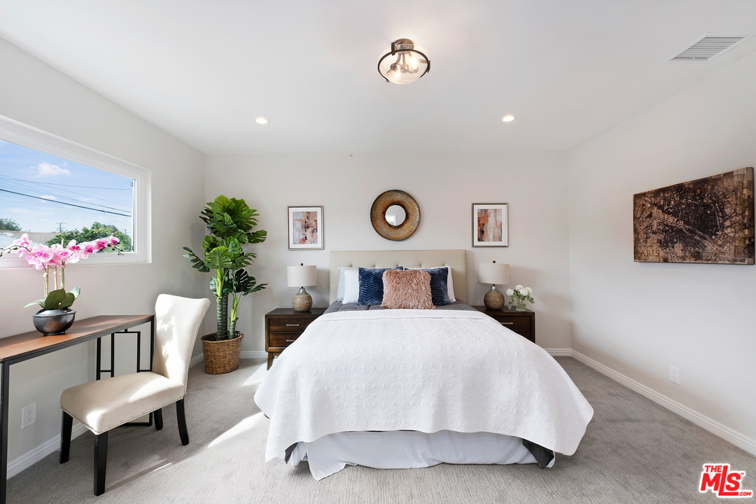 13927 Studebaker Road Norwalk, CA 90650 - Photo 13 of 27 a bedroom with a bed and a table