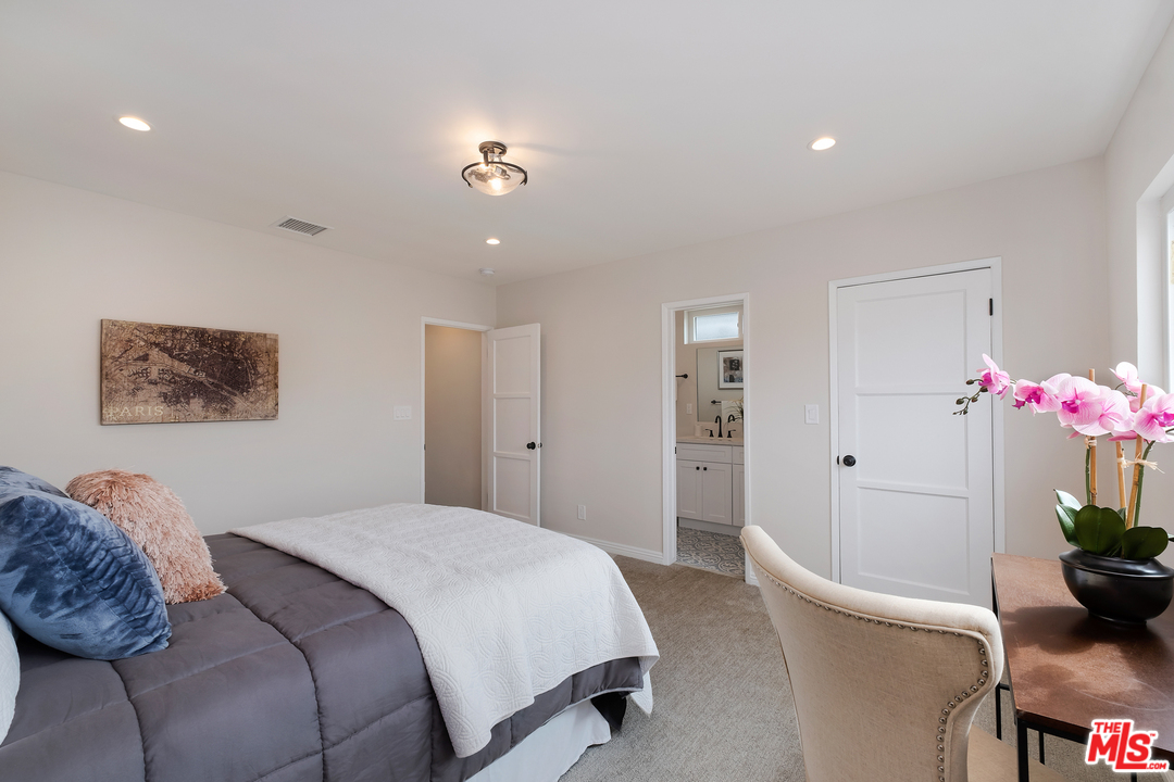 13927 Studebaker Road Norwalk, CA 90650 - Photo 14 of 27 a bedroom with a large bed and a potted plant
