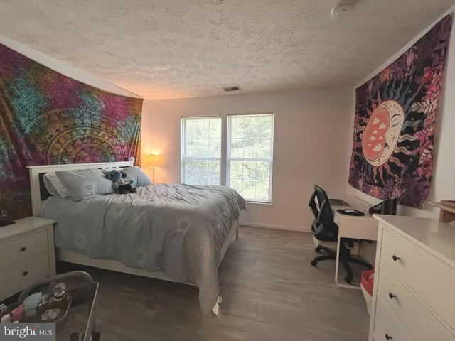 a bed sitting in a bedroom next to a window