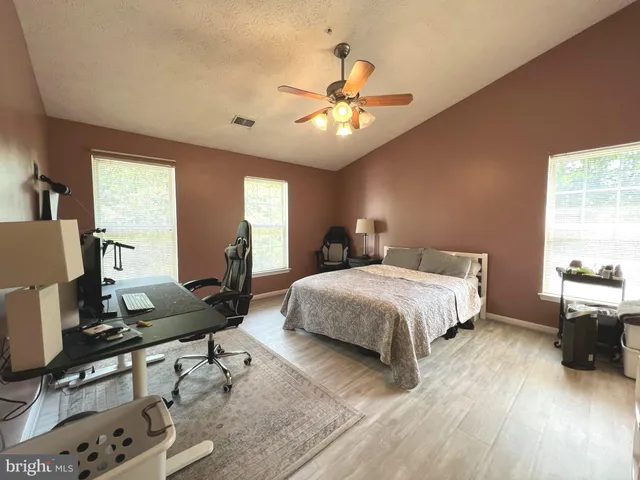 a spacious bedroom with a bed and a desk