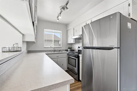 a kitchen with stainless steel appliances granite countertop a refrigerator and a sink