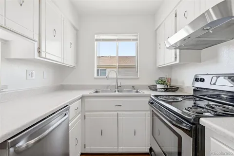 a kitchen with cabinets appliances a sink and a window
