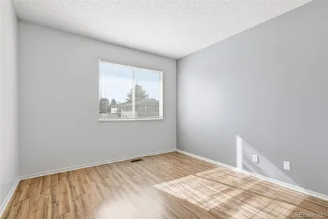 a view of a room with wooden floor and window