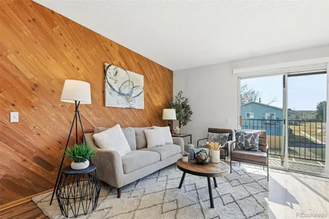 a living room with furniture and a floor to ceiling window