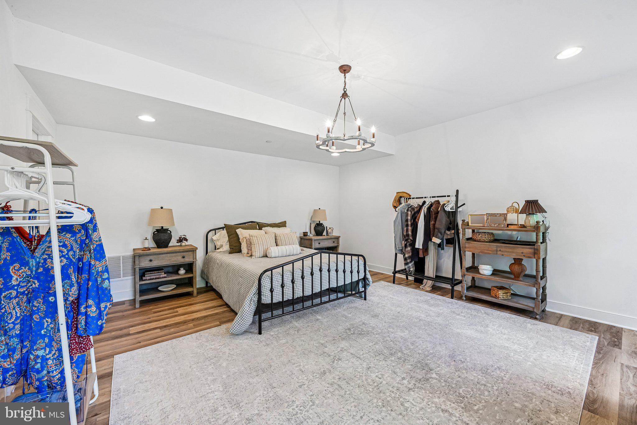 14516 Old Frederick Road Cooksville, MD 21723 - Photo 75 of 100 a spacious bedroom with furniture and a chandelier