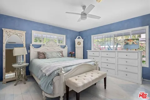 a bedroom with a bed a chandelier and a window