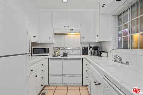 a kitchen with cabinets appliances and a sink