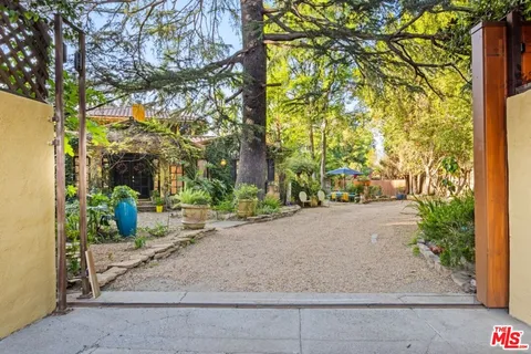 a backyard of a house with plants and tree