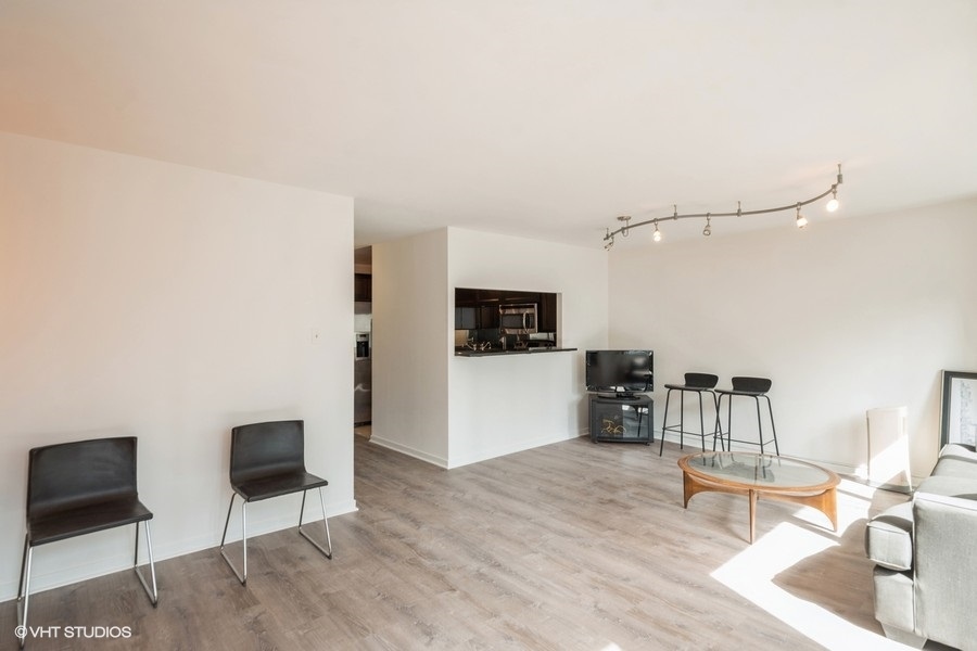 211 East Ohio Street, Unit 2012 Chicago, IL 60611 - Photo 2 of 19 a living room with furniture and a flat screen tv